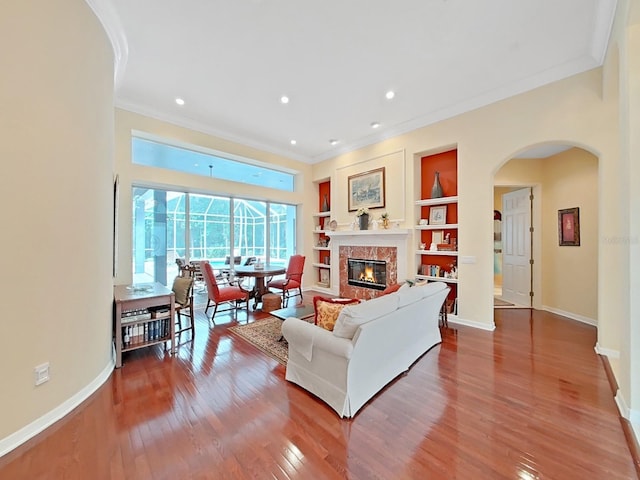 16343 Burniston Dr, Tampa, FL 33647 - living room with arched walkways, wood finished floors, crown molding, baseboards, and a fireplace