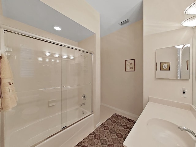 16343 Burniston Dr, Tampa, FL 33647 - full bathroom featuring shower / bath combination with glass door, vanity, and baseboards
