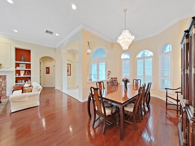16343 Burniston Dr, Tampa, FL 33647 - dining space with arched walkways, ornamental molding, dark wood finished floors, built in features, and baseboards