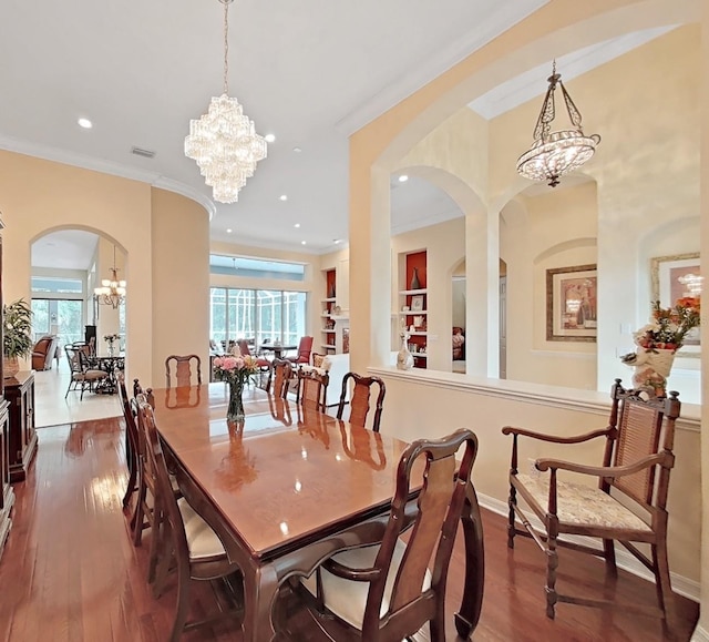 16343 Burniston Dr, Tampa, FL 33647 - dining room with a chandelier, arched walkways, plenty of natural light, dark wood-style flooring, and crown molding