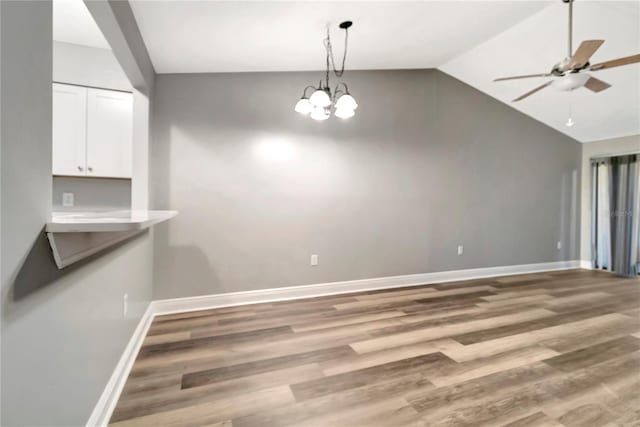 unfurnished dining area with ceiling fan, lofted ceiling, light wood-style flooring, and baseboards