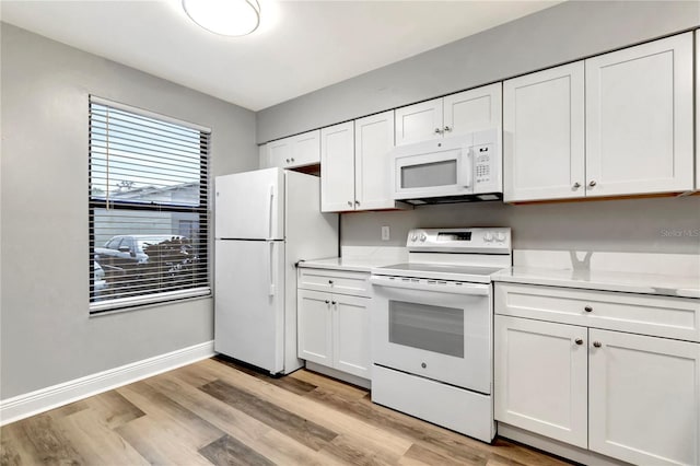 kitchen featuring white appliances, light wood-style floors, light countertops, and white cabinets
