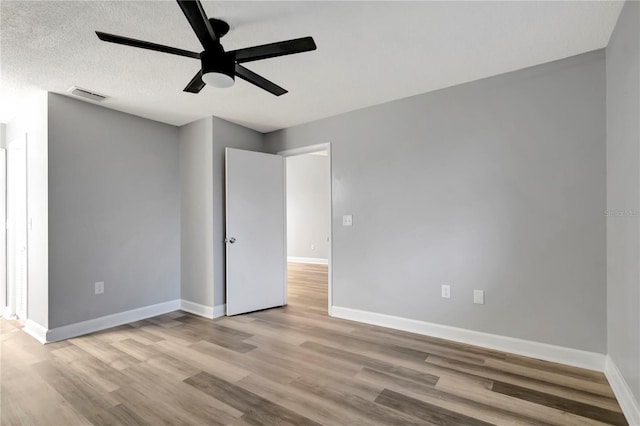 unfurnished bedroom featuring wood finished floors, baseboards, and a ceiling fan