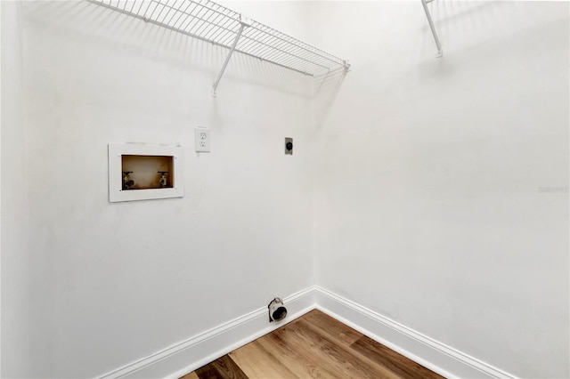 clothes washing area with baseboards, hookup for a washing machine, electric dryer hookup, and wood finished floors