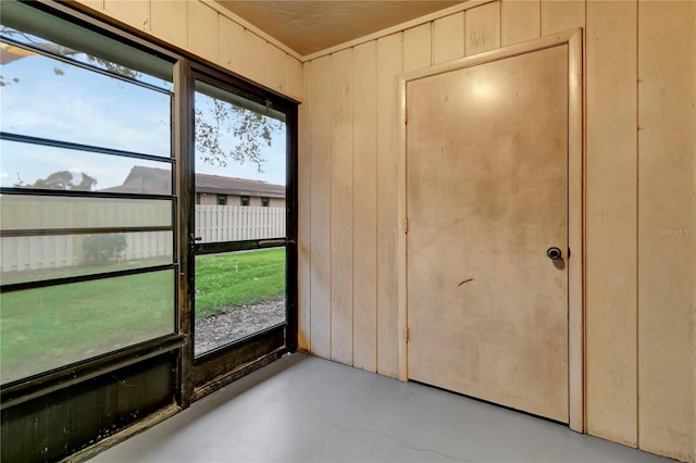interior space featuring concrete floors and wooden walls