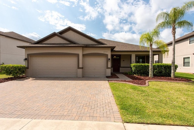 12352 Crestridge Loop, New Port Richey, FL 34655 - ranch-style home with decorative driveway, an attached garage, stucco siding, and a front yard