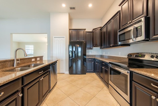 12352 Crestridge Loop, New Port Richey, FL 34655 - kitchen with stainless steel appliances, a sink, stone countertops, light tile patterned floors, and dark brown cabinets