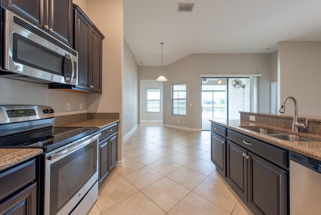 12352 Crestridge Loop, New Port Richey, FL 34655 - kitchen featuring appliances with stainless steel finishes, a sink, light tile patterned flooring, vaulted ceiling, and dark brown cabinets