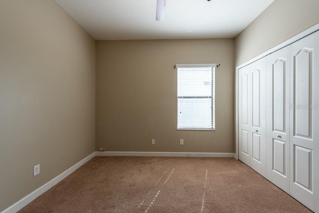 12352 Crestridge Loop, New Port Richey, FL 34655 - unfurnished bedroom featuring light colored carpet, a closet, baseboards, and a ceiling fan