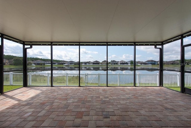 12352 Crestridge Loop, New Port Richey, FL 34655 - unfurnished sunroom with a water view, a residential view, a wall of windows, and brick floors