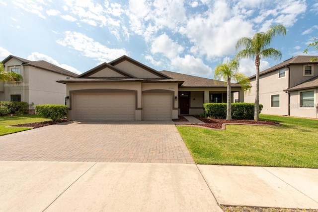 12352 Crestridge Loop, New Port Richey, FL 34655 - view of front of house featuring decorative driveway, an attached garage, stucco siding, and a front lawn