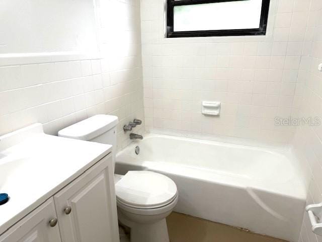 1138 Huss Rd, Wauchula, FL 33873 - full bathroom with tile walls, toilet, vanity, and washtub / shower combination