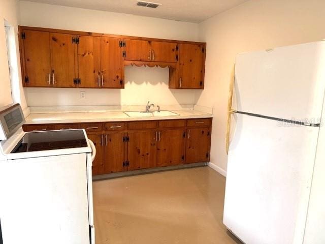 1138 Huss Rd, Wauchula, FL 33873 - kitchen with white appliances, a sink, brown cabinets, and light countertops