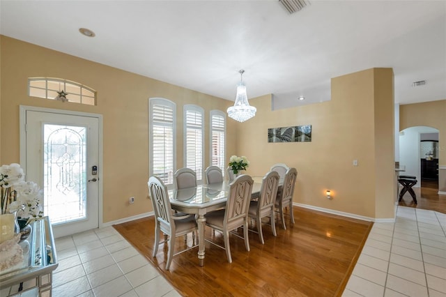 815 Sandy Trail Pl, Brandon, FL 33511 - dining area with arched walkways, light tile patterned floors, a chandelier, baseboards, and healthy amount of natural light