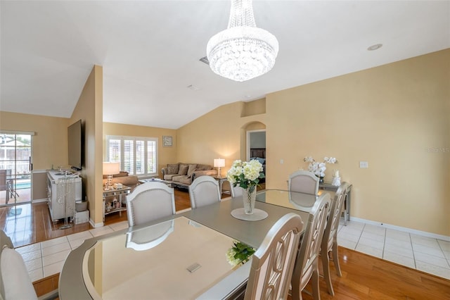 815 Sandy Trail Pl, Brandon, FL 33511 - dining space with lofted ceiling, a chandelier, wood finished floors, baseboards, and arched walkways
