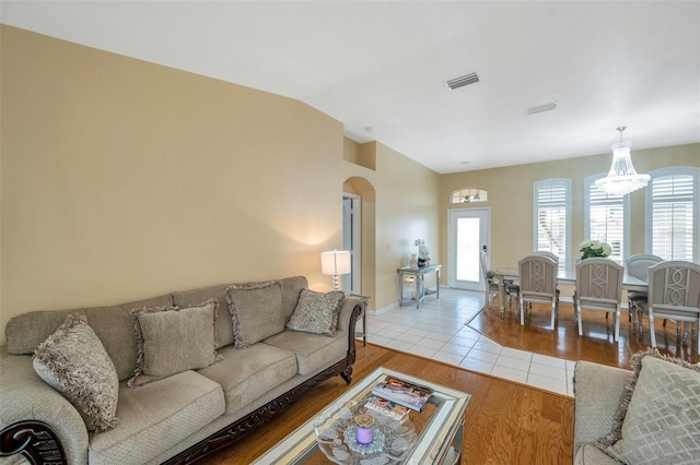 815 Sandy Trail Pl, Brandon, FL 33511 - living area with healthy amount of natural light, arched walkways, lofted ceiling, a chandelier, and light wood-style flooring