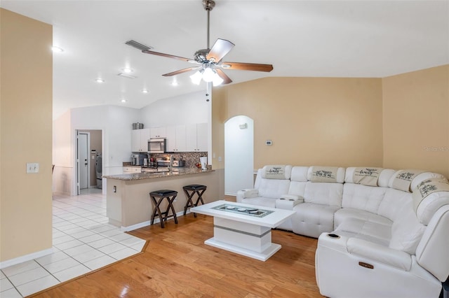 815 Sandy Trail Pl, Brandon, FL 33511 - living area with a ceiling fan, vaulted ceiling, arched walkways, and light wood-style flooring