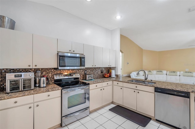 815 Sandy Trail Pl, Brandon, FL 33511 - kitchen with stainless steel appliances, a sink, vaulted ceiling, decorative backsplash, and arched walkways