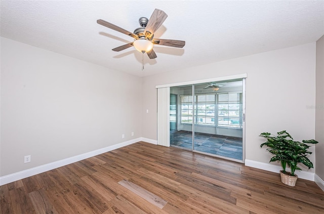unfurnished room featuring wood finished floors, a ceiling fan, and baseboards