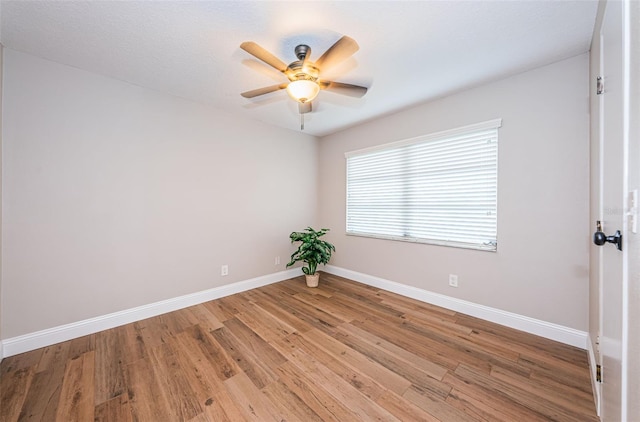 spare room with light wood-style floors, a ceiling fan, and baseboards