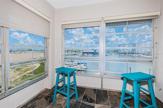 sunroom featuring a water view
