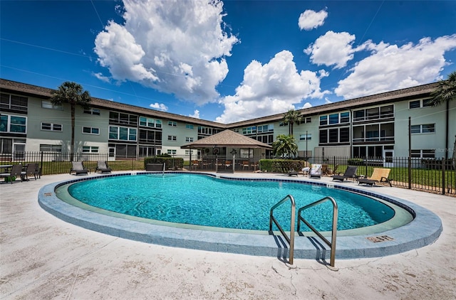 community pool with fence and a patio