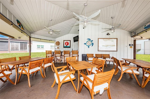 dining area with lofted ceiling, ceiling fan, and concrete flooring