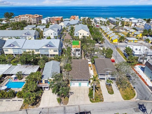 aerial perspective of suburban area with a pool area and a large body of water