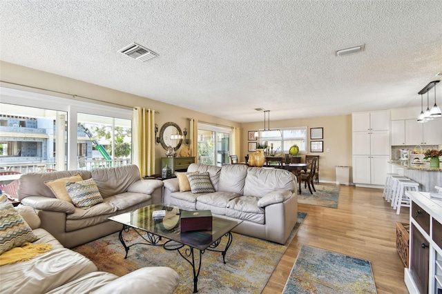 living room featuring light wood-style floors and a textured ceiling