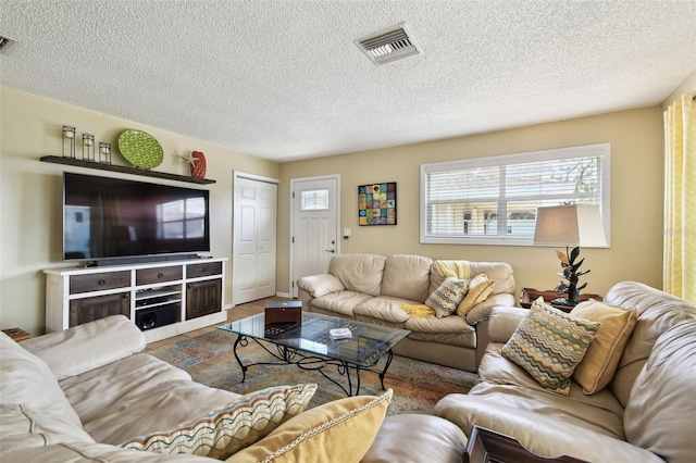 living area with a textured ceiling and wood finished floors