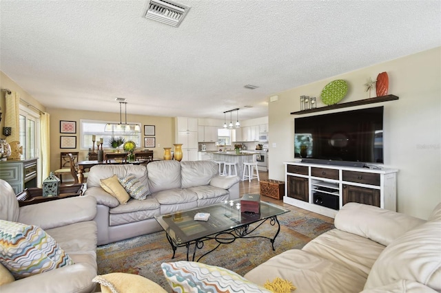 living area with a chandelier and a textured ceiling