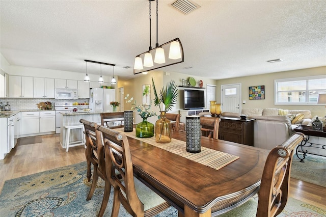 dining area featuring a textured ceiling and dark wood-style floors