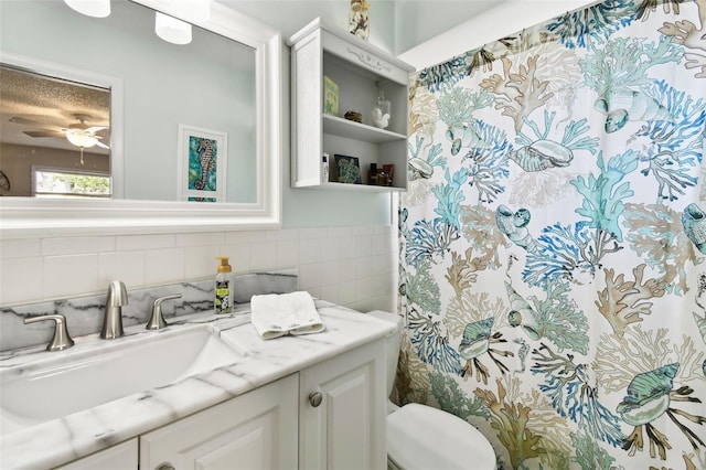 bathroom with toilet, vanity, ceiling fan, and a shower with curtain