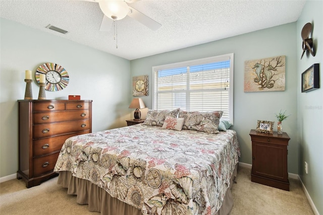 bedroom featuring light carpet, a textured ceiling, baseboards, and ceiling fan