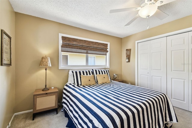 bedroom featuring carpet flooring, a closet, a ceiling fan, a textured ceiling, and baseboards