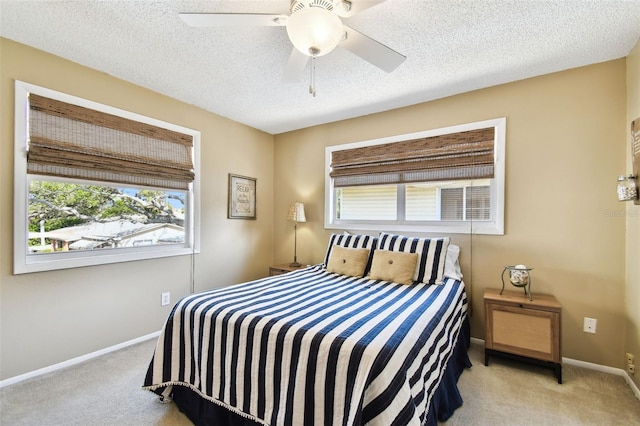bedroom featuring carpet floors, baseboards, ceiling fan, and a textured ceiling