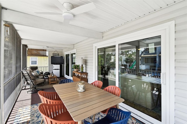 sunroom featuring ceiling fan and beam ceiling