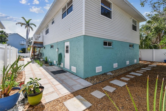 back of property with stucco siding, a fenced backyard, stairs, and a patio