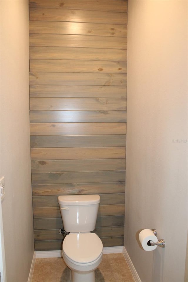 8009 Trimbelle Ter, Parrish, FL 34219 - bathroom with baseboards, toilet, tile patterned flooring, and wooden walls