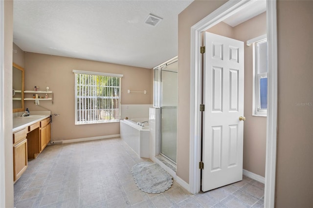 4222 Trumpworth Ct, Valrico, FL 33596 - bathroom featuring vanity, a garden tub, a shower stall, and baseboards