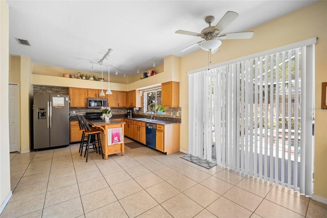 4222 Trumpworth Ct, Valrico, FL 33596 - kitchen featuring appliances with stainless steel finishes, dark countertops, decorative backsplash, a breakfast bar, and light tile patterned floors