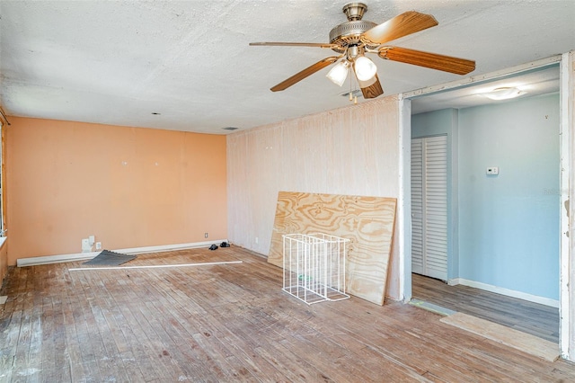unfurnished living room with wood finished floors, baseboards, and ceiling fan