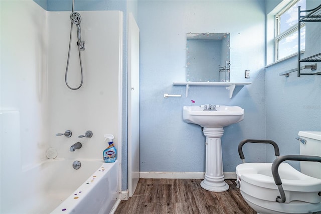 bathroom with wood finished floors, baseboards, and shower / bath combination