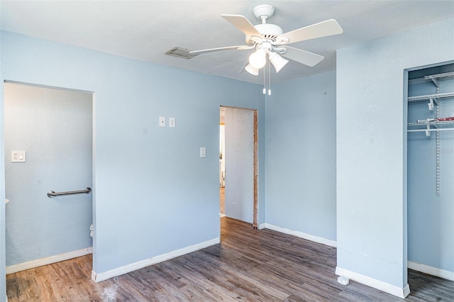 unfurnished bedroom with wood finished floors, a closet, baseboards, and ceiling fan
