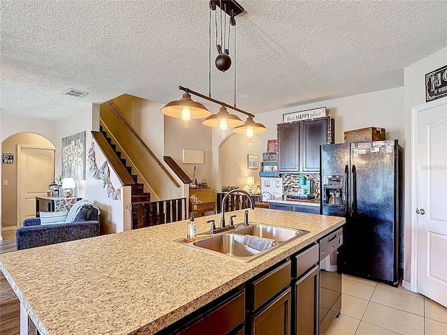 159 Lazy Willow Dr, Davenport, FL 33897 - kitchen with arched walkways, a sink, black refrigerator with ice dispenser, dishwashing machine, and light countertops