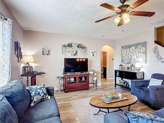 159 Lazy Willow Dr, Davenport, FL 33897 - living area featuring arched walkways, ceiling fan, light wood-type flooring, a textured ceiling, and baseboards