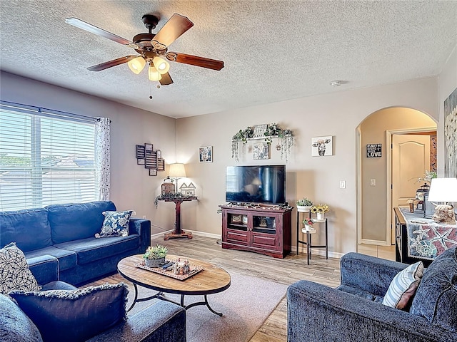 159 Lazy Willow Dr, Davenport, FL 33897 - living room with arched walkways, wood finished floors, ceiling fan, a textured ceiling, and baseboards