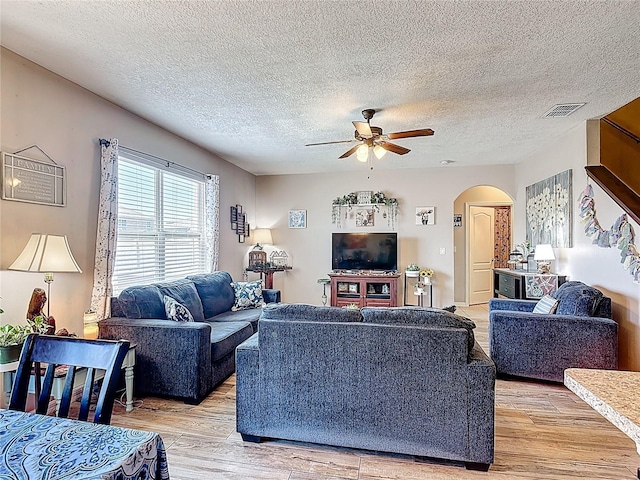 159 Lazy Willow Dr, Davenport, FL 33897 - living area featuring arched walkways, light wood-style flooring, a ceiling fan, and a textured ceiling