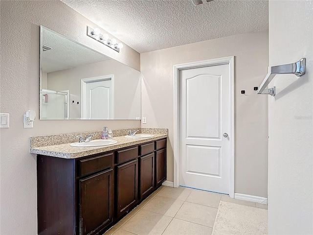 159 Lazy Willow Dr, Davenport, FL 33897 - full bathroom with tile patterned flooring, double vanity, a textured ceiling, and baseboards