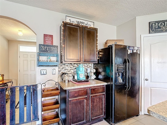 159 Lazy Willow Dr, Davenport, FL 33897 - kitchen featuring black refrigerator with ice dispenser, arched walkways, a textured ceiling, light countertops, and backsplash